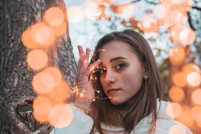 Portrait of young woman holding camera