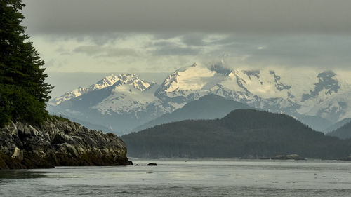 Scenic view of sea and mountains against sky