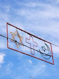 Low angle view of sign against blue sky