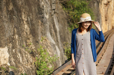 Young woman standing against the wall