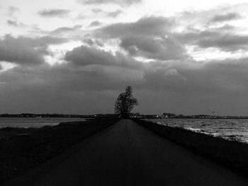 Road amidst trees against sky