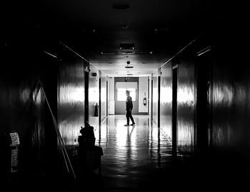 Man walking in illuminated corridor