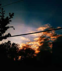 Low angle view of silhouette trees against sky at sunset