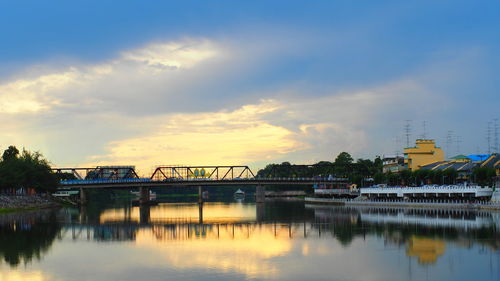 Bridge over river against sky during sunset