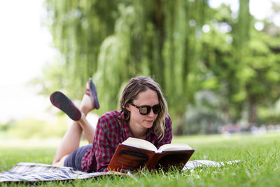 A young woman reads a book in a park in the columbia gorge.