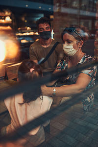 People wearing mask sitting in cafe