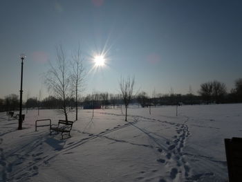 Scenic view of snow covered field against sky