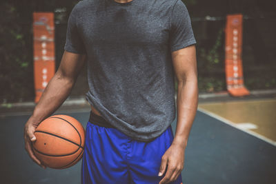 Midsection of man holding ball on table