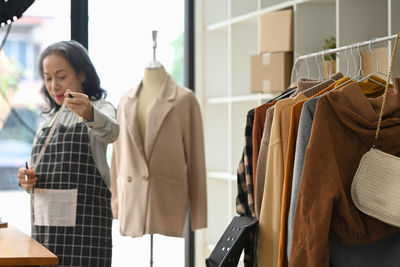 Portrait of young woman standing against wall