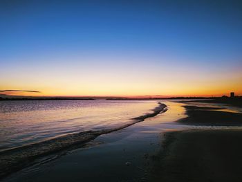 Scenic view of sea against clear sky at sunset