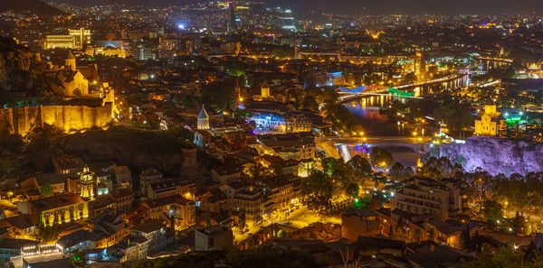 High angle view of city lit up at night