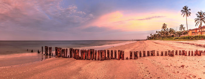 Old pier in the ocean at port royal beach at sunrise in naples, florida