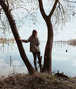 Woman by tree against sky