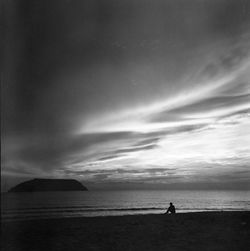 Silhouette man standing on beach against sky
