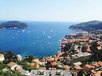 High angle view of cityscape by sea against clear sky