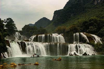 Scenic view of waterfall against sky