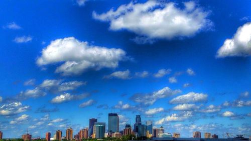 Low angle view of modern buildings against blue sky