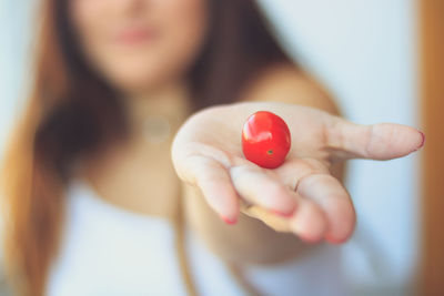 Close-up of hand holding red berries or tomatoes