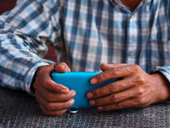 Midsection of man using mobile phone