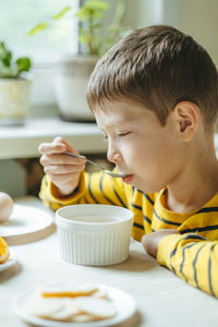 Boy eats breakfast in the morning with cereals with milk. morning breakfast in the kitchen