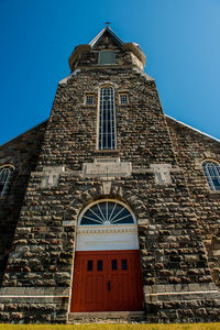 Low angle view of bell tower against blue sky