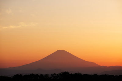 Scenic view of silhouette mountains against romantic sky at sunset