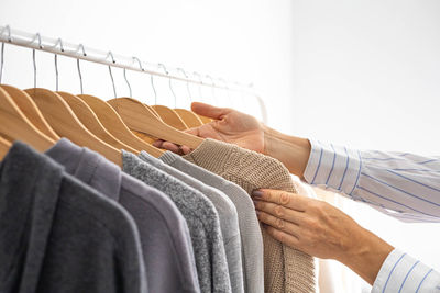 Midsection of woman holding clothes hanging on rope