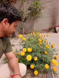 Midsection of man holding yellow flowering plant