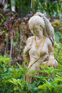 Statue of buddha against plants