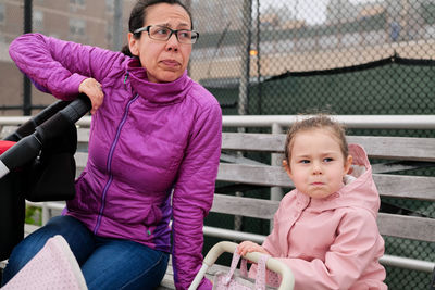 Mom and daughter with identical facial expression enjoing a day on the boardwalk