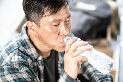 Close-up of beggar drinking water in city