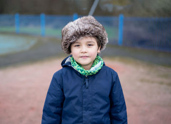 Portrait of smiling boy standing outdoors in winter