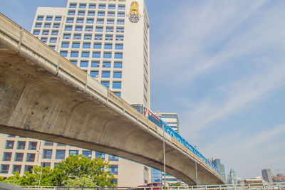 Low angle view of bridge and buildings against sky