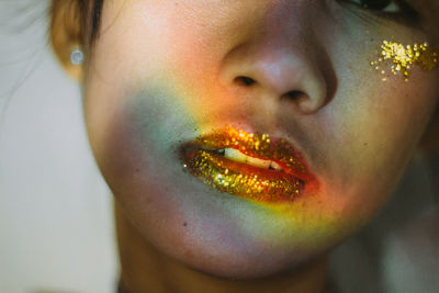 Close-up of young woman wearing glitter on lips