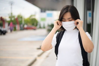 Portrait of beautiful woman standing on street in city
