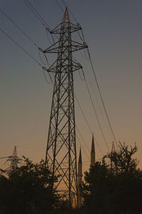 Low angle view of silhouette electricity pylon against sky