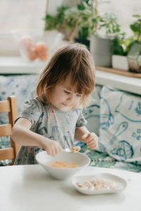 High angle view of girl sitting on table