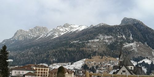 Panoramic view of townscape by mountain against sky