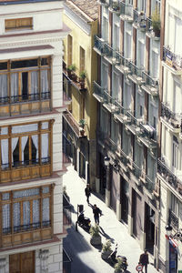 People walking on street amidst buildings in city