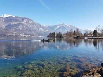 Scenic view of lake and snowcapped mountains against sky