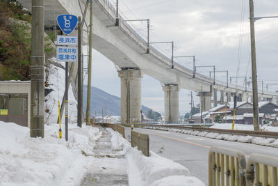 Bridge over road against sky during winter
