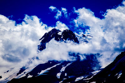 Scenic view of clouds over mountains against sky