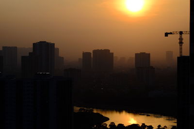 Silhouette buildings against romantic sky at sunset