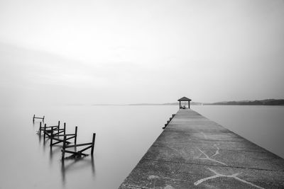 Pier over lake against sky