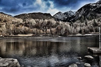 Scenic view of lake by mountains against sky