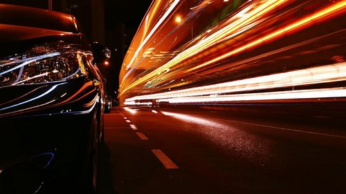 Illuminated light trail by car on road at night