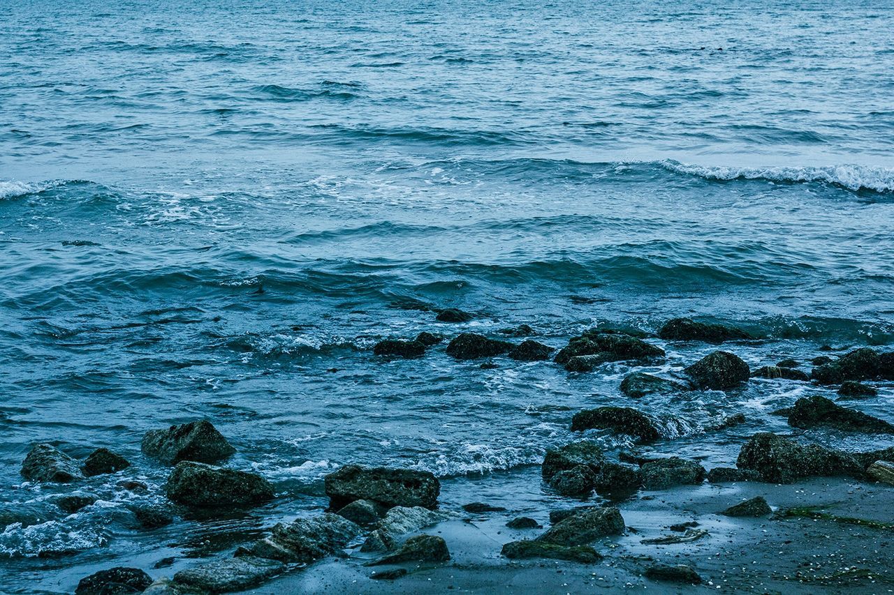 water, sea, wave, rippled, beauty in nature, nature, high angle view, tranquility, scenics, surf, tranquil scene, waterfront, shore, blue, beach, day, seascape, no people, rock - object, outdoors