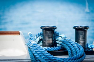 Close-up of rope tied to bollard by sea