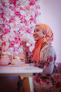 Woman with pink flowers on table