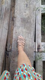 Low section of woman standing on wooden floor